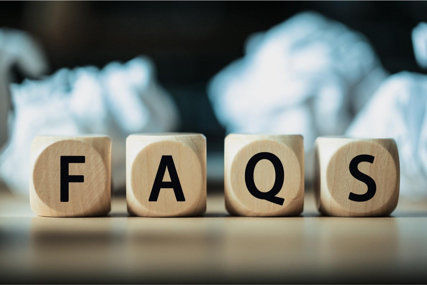 Wooden blocks spelling ‘FAQS’ placed on a desk, representing frequently asked questions related to GST compliance, tax updates, and regulatory guidance.